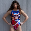 Ragazza modella di fronte con costume da allenamento nuoto Boneswimmer, modello intero PINUP 332p con stampa di una figura stilizzata di guerriera teschio con elmo e armatura con effetti luminosi su sfondo scuro