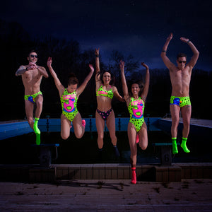 Cinque modelli saltano da un gradino indossando un costume da allenamento nuoto Boneswimmer (per le donne il PINUP 334pf), tutti con stampe di una papera con occhialini da nuoto su sfondo giallo
