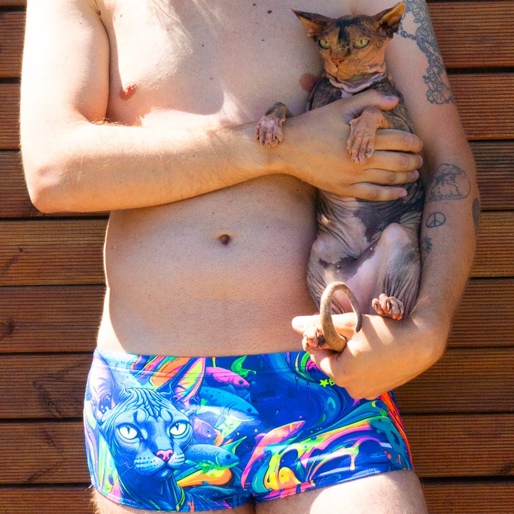 Un modello indossa il costume parigamba da uomo UCLA MARGÔ con un gatto sphinx che ha ispirato il personaggio della linea