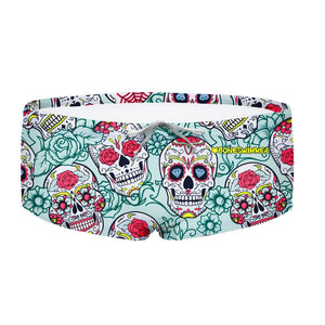 Costume da allenamento nuoto in piscina Boneswimmer da uomo, modello parigamba UCLA 208UF TESCHI MEX con motivo teschi floreali in stile Día de Muertos con colori accesi su sfondo celeste; fronte
